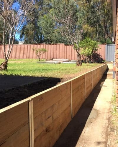 Timber sleeper retaining wall and boundary fence by Fineline Fencing Melbourne